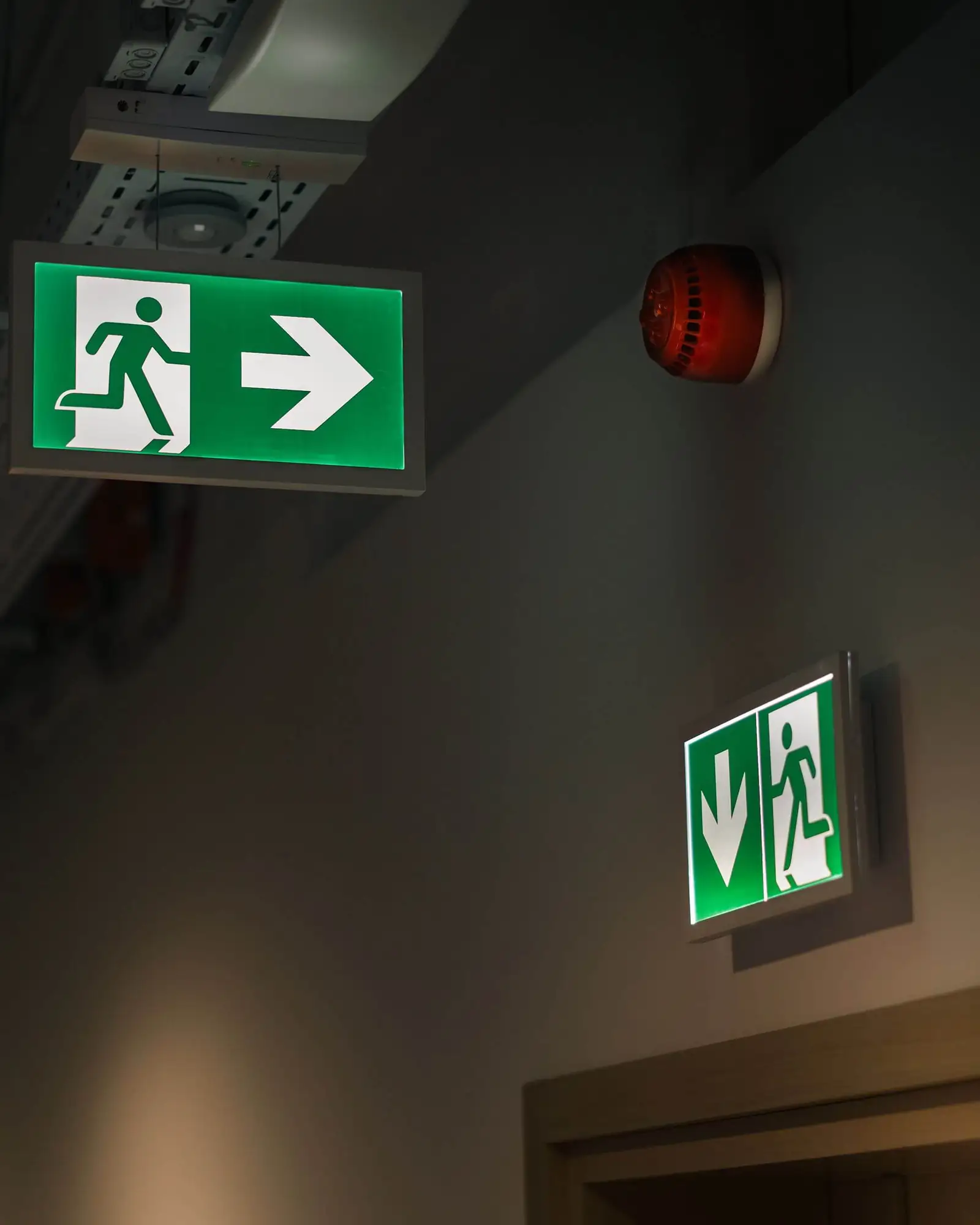 Illuminated fire exit signs and alarm sounder inside a commercial building